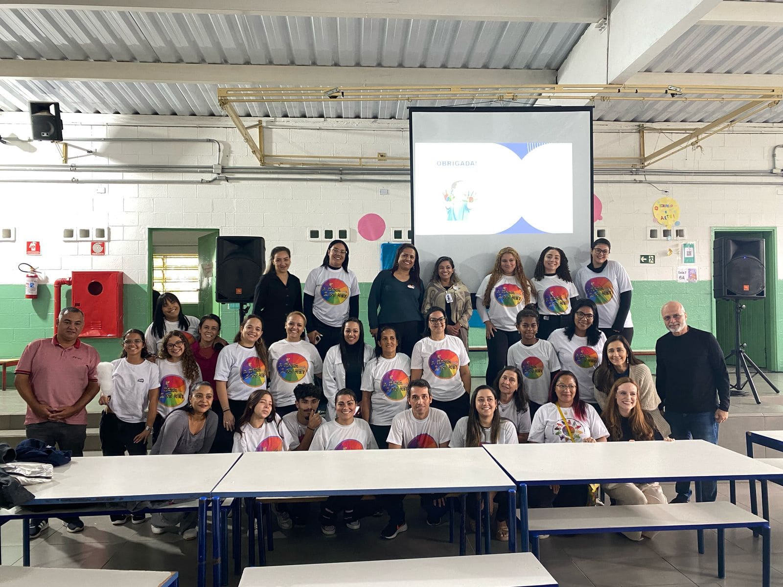 Uma palestra para um grupo de pessoas sentadas em cadeiras e atentos ao que está sendo dito.